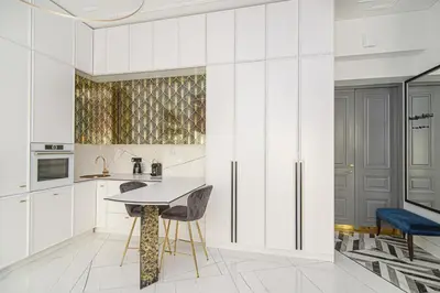 a kitchen with white cabinets and a table and chairs at Apartment Gedimino 22 in Vilnius