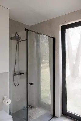 a shower with a glass door in a bathroom at Vienis glamping - cozy and private forest house in Randamonys