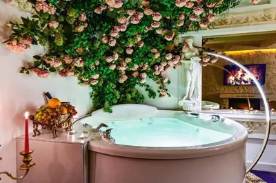 a bathroom with a tub with flowers on the wall at HOST apartment 3 in Kaunas
