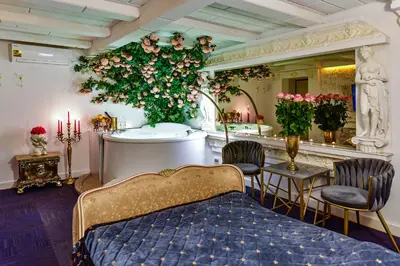 a room with a bed and a tub with flowers at HOST apartment 3 in Kaunas
