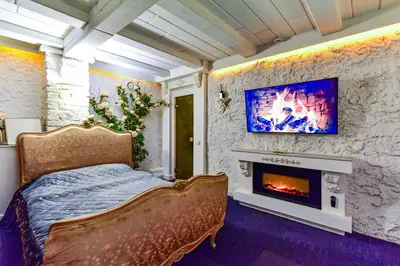 a bedroom with a bed with a fireplace and a tv at HOST apartment 3 in Kaunas
