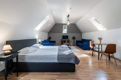 a bedroom with a bed and a couch and a table at Avanti apgyvendinimas-restoranas in Biržai