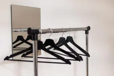 a rack of black hangers in front of a mirror at Avanti apgyvendinimas-restoranas in Biržai