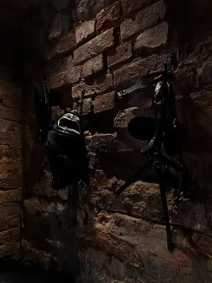 a stone wall with a helmet hanging on it at FETISH Room in Kaunas