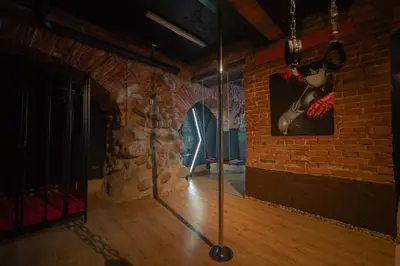 a room with a brick wall with a painting of a woman at FETISH Room in Kaunas