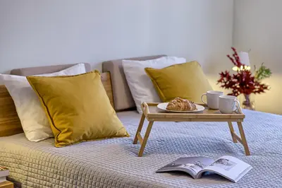 a coffee table with a plate of food on a bed at Family Oasis Apartments x Free parking x SELF CHECK IN 24x7 in Vilnius