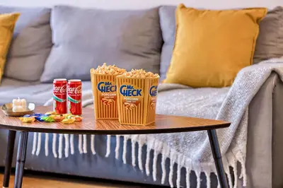 a coffee table with popcorn and snacks on a couch at Family Oasis Apartments x Free parking x SELF CHECK IN 24x7 in Vilnius