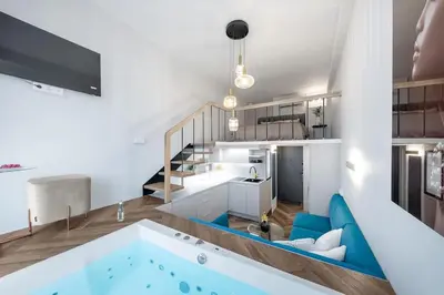 a kitchen and a living room with a bath tub at Vega - Whirlpool - Self Checkin in Vilnius