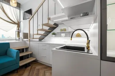 a kitchen with a sink and a spiral staircase at Vega - Whirlpool - Self Checkin in Vilnius
