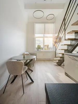 a living room with a table and a staircase at Modern loft in City centre Self check-in No 45 in Vilnius