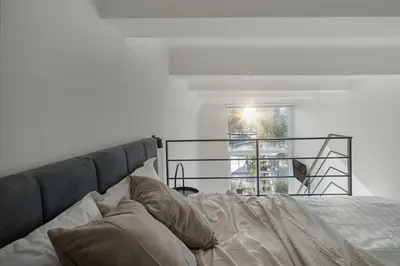 a bedroom with a bed with pillows and a window at Modern loft in City centre Self check-in No 45 in Vilnius
