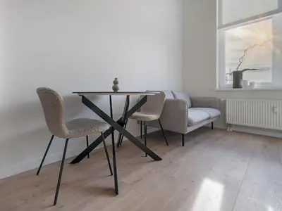 a table and chairs in a room with a window at Modern loft in City centre Self check-in No 45 in Vilnius