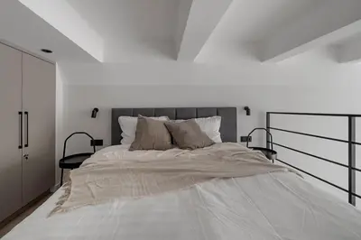 a white bedroom with a large white bed with pillows at Modern loft in City centre Self check-in No 45 in Vilnius