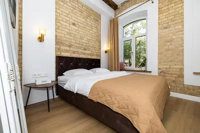 a bedroom with a bed and a brick wall at cohost I Brand New Apt, w-AC in a Central Location in Vilnius