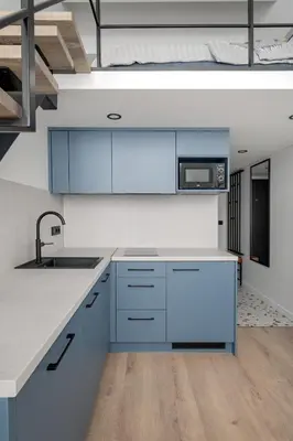 an open kitchen with blue cabinets and a sink at Modern loft in City centre Self check-in No 47 in Vilnius