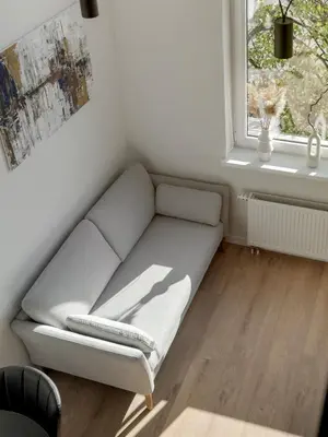 a couch in a living room with a window at Modern loft in City centre Self check-in No 47 in Vilnius
