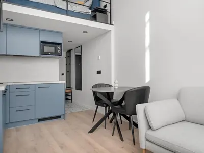 a kitchen and living room with a table and a couch at Modern loft in City centre Self check-in No 47 in Vilnius