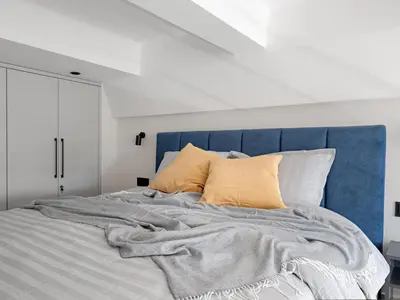 a bed with a blue head board and pillows at Modern loft in City centre Self check-in No 47 in Vilnius