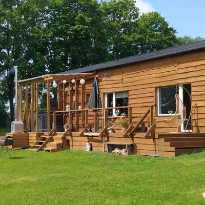 a log cabin with a porch and a deck at Sodyba Po klevais in Meištai