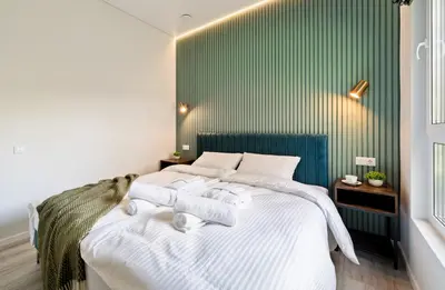 a bedroom with a white bed with towels on it at Beržynė Villas in Liepiškės