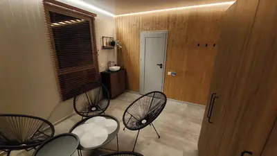a room with three chairs and a table and a door at Beržynė Villas in Liepiškės