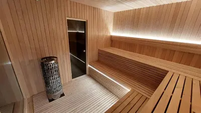 a sauna with a bench in the middle of it at Beržynė Villas in Liepiškės