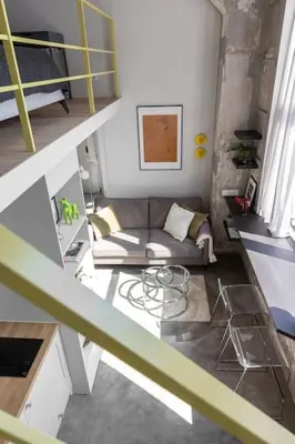 a living room with a couch and a table at Artsy Design Loft - Hip District Uptown Vilnius in Vilnius