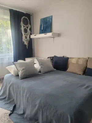 a bedroom with a large blue bed with pillows at Cozy apartment Akropolis in Vilnius