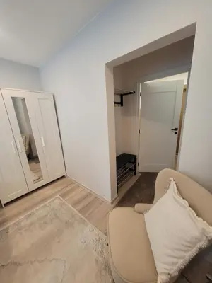 a living room with a couch and a mirror at Cozy apartment Akropolis in Vilnius