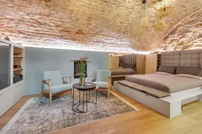 a bedroom with a bed and a table and chairs at Historic & modern Arch-Studio - ArcLoft07 in Vilnius