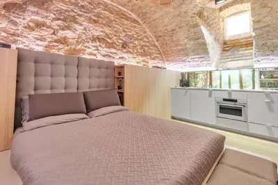 a bedroom with a large bed and a brick wall at Historic & modern Arch-Studio - ArcLoft07 in Vilnius