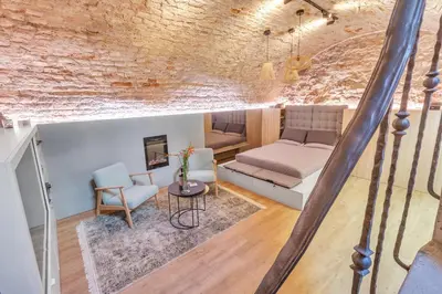 a living room with a bed and a couch at Historic & modern Arch-Studio - ArcLoft07 in Vilnius