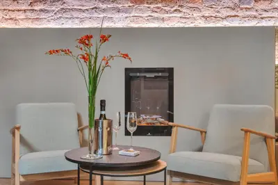 a table with a vase of flowers and two chairs at Historic & modern Arch-Studio - ArcLoft07 in Vilnius