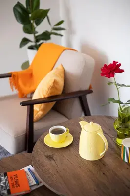 a table with a cup of coffee and a tea pot at Spirit Of 70s Apartment in Vilnius