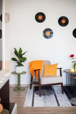 a living room with a chair and a table at Spirit Of 70s Apartment in Vilnius