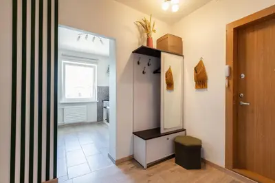 a hallway with a bathroom with a mirror and a door at Spirit Of 70s Apartment in Vilnius