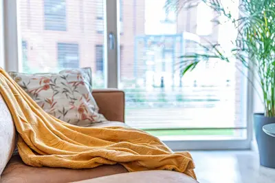 a blanket sitting on a couch in a living room at River Park Apartment in Kaunas