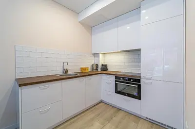 a white kitchen with white cabinets and a sink at River Park Apartment in Kaunas