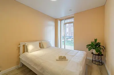 a bedroom with a white bed with a window at River Park Apartment in Kaunas
