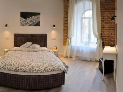 a bedroom with a large bed and a brick wall at Happy Inn Lux apartment, self Check, parking, Tilto str in Vilnius