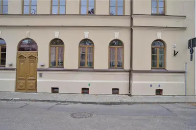 a building with brown doors and windows on a street at Happy Inn Lux apartment, self Check, parking, Tilto str in Vilnius