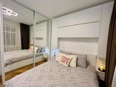 a bedroom with a bed with a mirrored wall at Modern 1-Bedroom Apartment in Kaunas Downtown in Kaunas