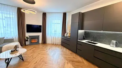 a kitchen with a living room with a fireplace at Modern 1-Bedroom Apartment in Kaunas Downtown in Kaunas