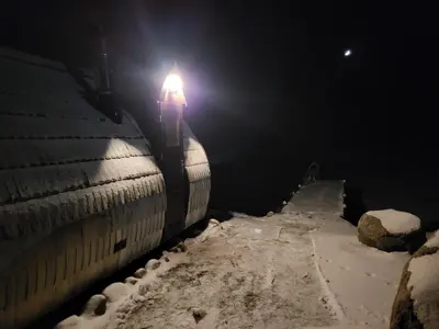 a train with a light on the side of a tunnel at Pine Valley Villa - beautiful nature, jacuzzi, sauna, cozy log house in Inturkė