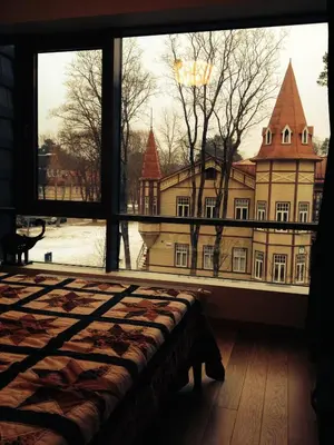 a bedroom with a large window looking out at a building at Apartment in Druskininkai Lithuania in Druskininkai