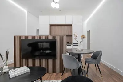 a living room with a table and chairs and a television at Modern Apartment in the heart of Vilnius Old Town with free parking by URBAN RENT in Vilnius