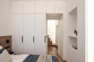 a bedroom with white cabinets and a bed at Modern Apartment in the heart of Vilnius Old Town with free parking by URBAN RENT in Vilnius