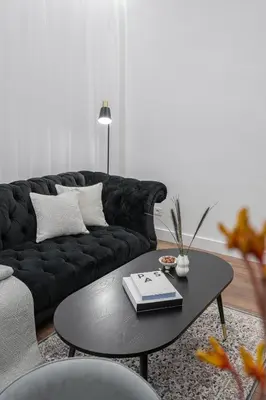 a living room with a black couch and a table at Modern Apartment in the heart of Vilnius Old Town with free parking by URBAN RENT in Vilnius