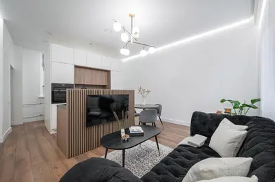 a living room with a couch and a tv at Modern Apartment in the heart of Vilnius Old Town with free parking by URBAN RENT in Vilnius