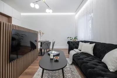 a living room with a black couch and a table at Modern Apartment in the heart of Vilnius Old Town with free parking by URBAN RENT in Vilnius